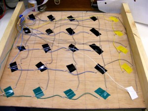 The bottom of the game board. Reed switches attached with coloured electrical tape to make logical layout.